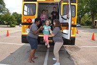 Bus drivers help students off a bus