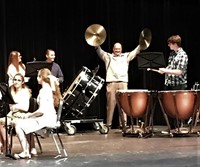 Principal Todd Spinner on stage holding cymbals while preforming with with the Westerville Central Symphonic Band.