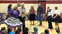 Square dancers perform for students