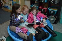 Second grade students enjoy some flashlight reading.