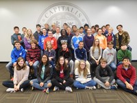 Forty students from Blendon, Genoa, Heritage and Walnut Springs Middle Schools sit in front the Capital University Seal