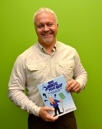Mike Ward holds his recently published a book titled, Who Swings Your Mop?  The Common Sense Approach to Custodial Work. 