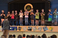 Students on stage performing songs.