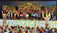 Students on stage performing Singin’ in the Rainforest
