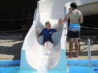 A student cools off on a water slide at the Jaycee Pool
