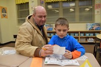 A student and his father enjoy reading activities