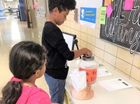 A fifth grader makes a donation. 