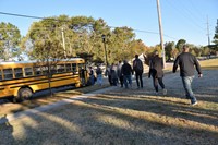 Students board a school bus during the district's reunification drill on October 16.