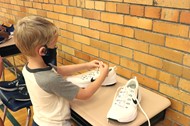 A Hanby student practices tying a shoe