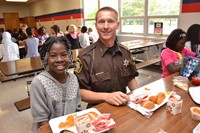 A student eating lunch with a DARE officer